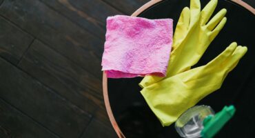 Household cleaning products arranged on a kitchen counter, illustrating domestic work and rising household employment costs.