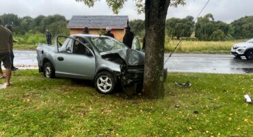 Damaged Open bakkie resting against a tree after Ermelo intersection accident.