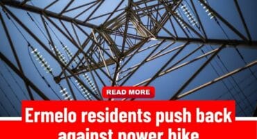 Electricity transmission tower viewed from below against a clear blue sky