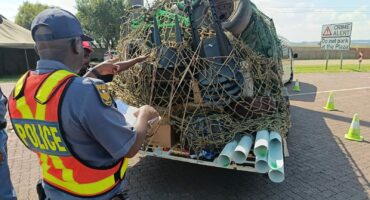 Police officer pulls over vehicle at roadside checkpoint in Mpumalanga