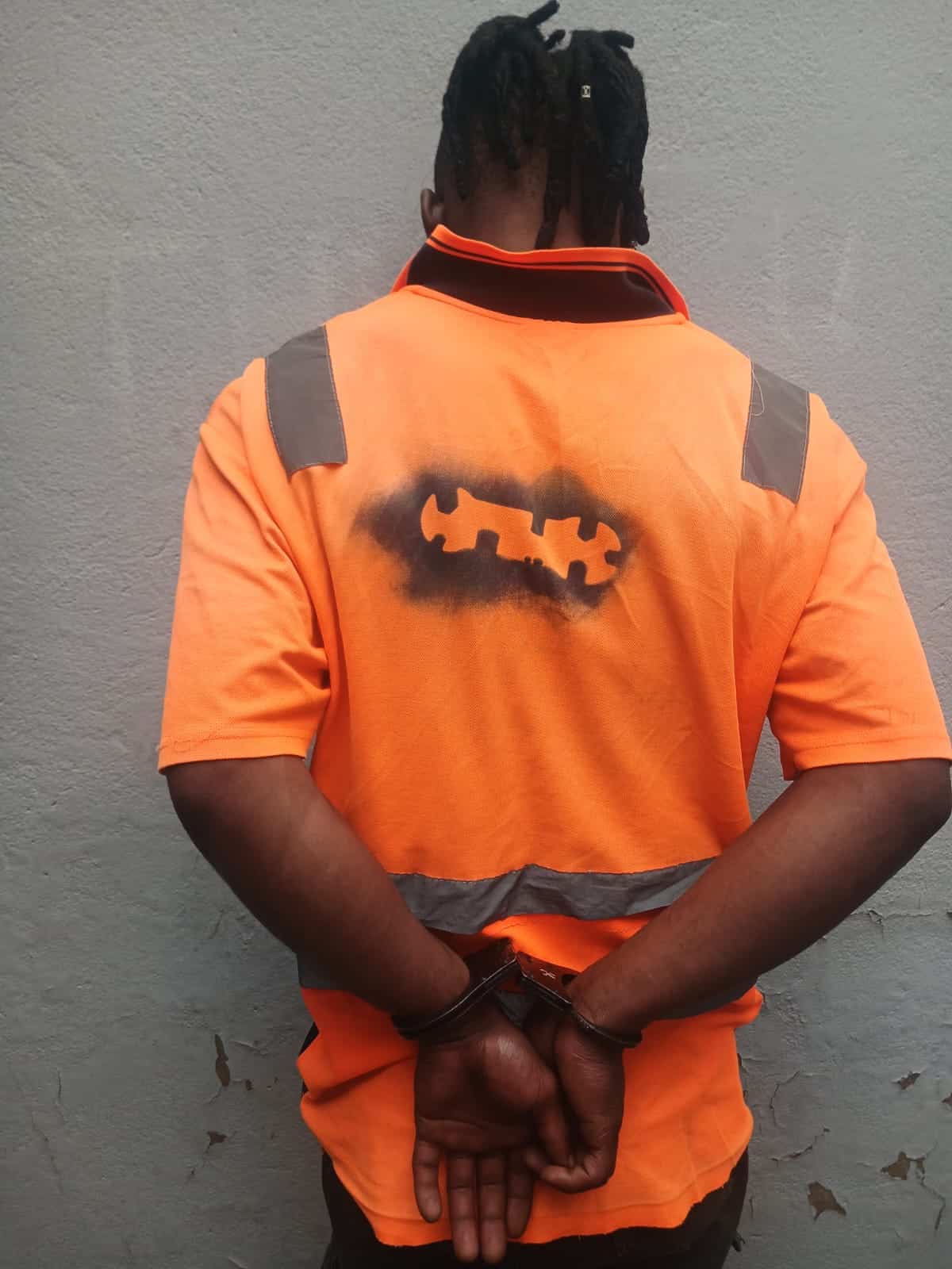 Handcuffed suspect seen from behind during arrest in Breyten.