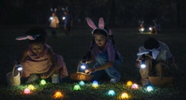Children hunting glowing Easter eggs at night in Ermelo with flashlights
