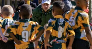 Marnus Marx staan langs die veld en kyk na mini-rugby en netbal