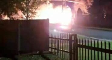 Helder flits en ligglans naby straat agter ’n heining in die nag
