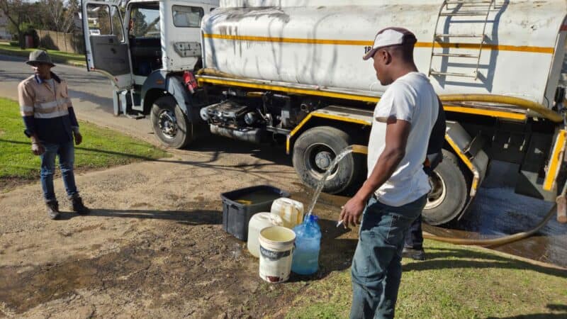 Inwoners in Generaal Bothastraat skep water uit ’n konstruksievoertuig tydens Ermelo se watertekorte