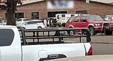 Police vehicles and officials outside a business premises during an immigration compliance operation in Ermelo.