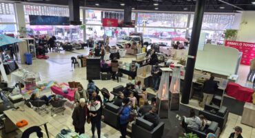 Visitors browse stalls and gather inside the Ermelo Toyota showroom during the Legend Fest despite cold winter weather.