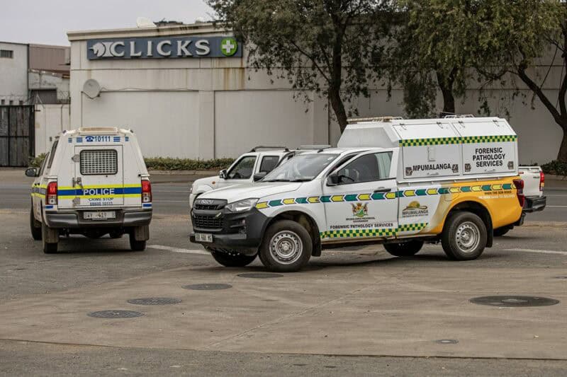 South African Police Service and Forensic Pathology Services vehicles parked near the scene where an unidentified man was found in Ermelo.