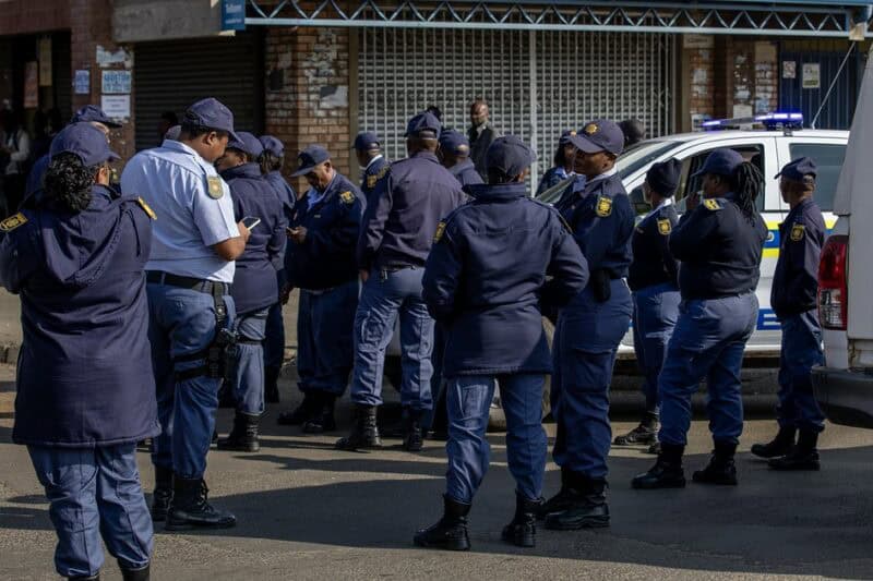 Police officers and security personnel monitoring a small gathering in Ermelo.