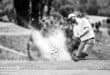 A golfer plays a bunker shot during a golf tournament.