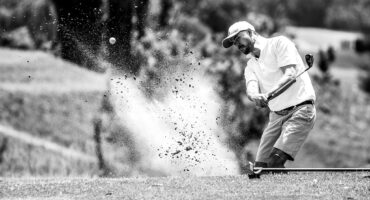 A golfer plays a bunker shot during a golf tournament.