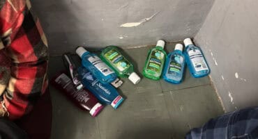 Several personal care products, including bottles of mouthwash, Satiskin products and a packaged toothbrush.