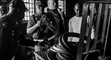 Local police officers, Fidelity Security manager Tinus Jansen van Vuuren and Transnet senior investigating officer Rendani Nemaguvhuni inspect recovered manhole covers and rings on a forklift at an Ermelo scrap yard.