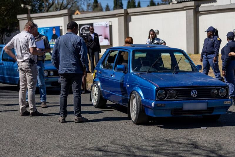 olice and security personnel near a blue Volkswagen Citi Golf following an alleged attempted car theft.