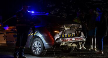 Police and traffic officials stand beside the damaged Msukaligwa Traffic Department vehicle following the collision.