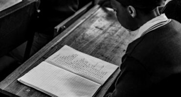 Learner rehearses a poem from an open book before reciting it to her peers during the BookHive programme.