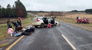 Two vehicles damaged in a serious collision on the R33 near Amsterdam, with several people visible at the roadside.
