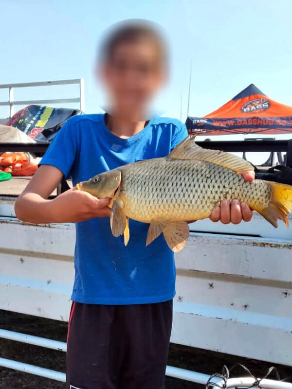 CMR CYCC child shows off his catch after fishing at Ons Pan.