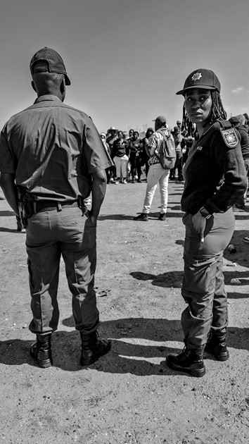Police officers stand near a group gathered in Wesselton, Ermelo.