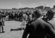 People gather under police observation near the Mpumalanga Stadium in Wesselton.