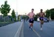 Two smiling runners wearing purple Daredevil speedos over black shorts run in Ermelo.