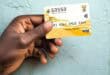 A hand holding a SASSA card, with text announcing new November payment dates.