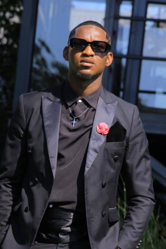 Ermelo model and presenter Siphamandla Nkosi wearing a black formal suit and sunglasses.