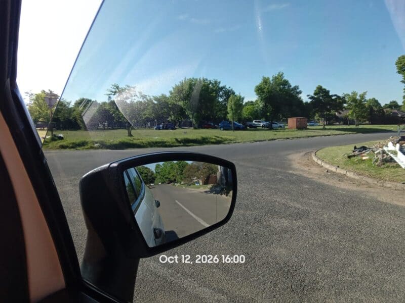 Voertuie staan op ’n oop grasgebied in Van Zylstraat, Ermelo, waar inwoners oor gereelde byeenkomste, lawaai en rommelstrooiery kla.