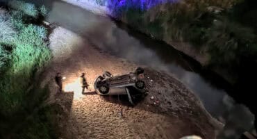 Nooddienste staan naby die Hyundai i20 wat onder ’n brug op die Lothairpad beland het.