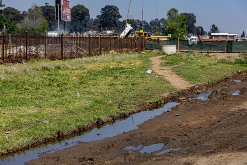 Wastewater runs alongside a muddy road near Lindile Secondary School in Wesselton.