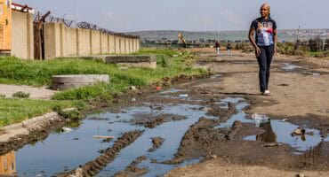 Owethu Rubeka stands in Sulima Street, where sewage collects near her family’s home and preschool.