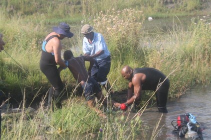 One of the bodies is taken out of the water.