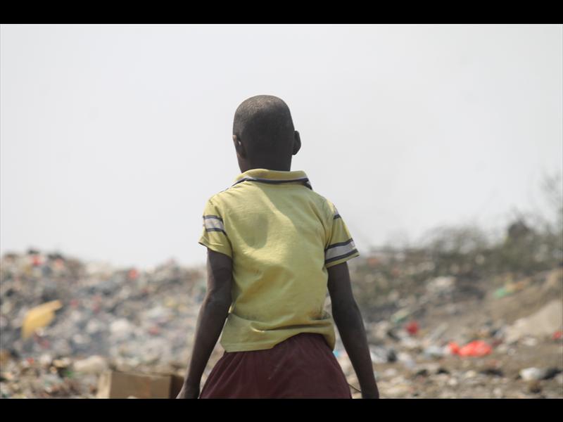This young boy is helping his parents find recyclables at the eMzinoni dumping site.