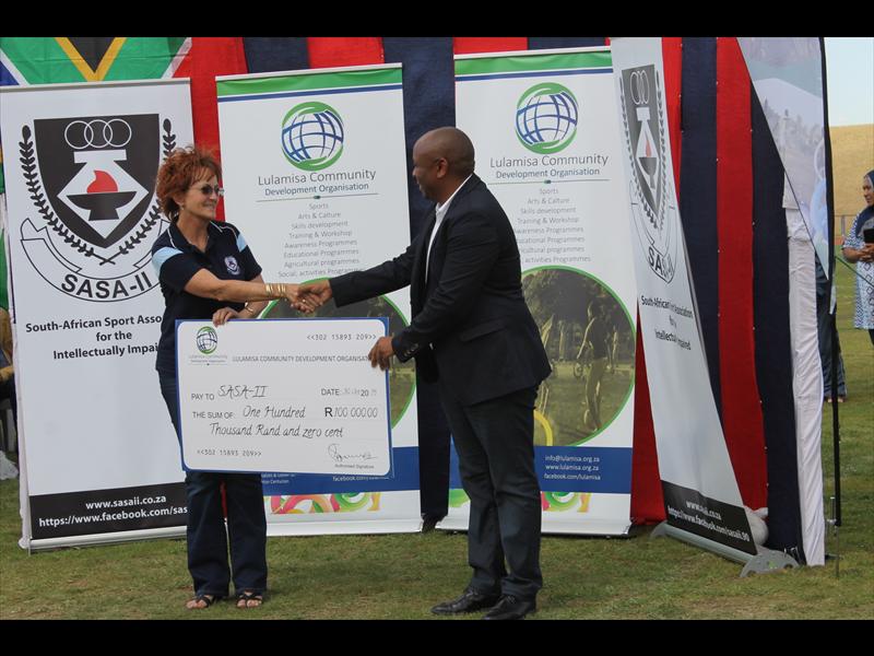 The chairman of Lulamisa Community Development Organisation, Mr Malwandla Siweya, hands over R100 000 to the president of SASAII, Ms Lizzy Vogel.