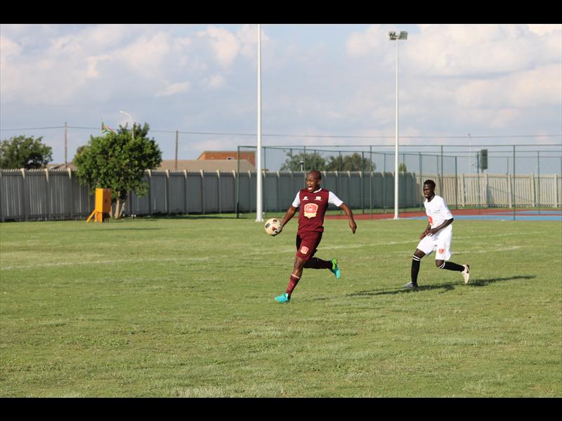 John Nazo (Stone Breaker FC) passes the ball into the 18th area.