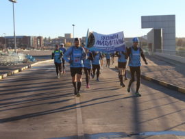 Leading the pack with their banner held high, are Hannes Prinsloo and Dirk van den Heever of Secunda Marathon Club.