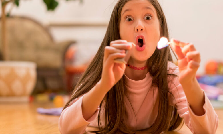 Girl playing with matches. Dangerous situation at home. A small child plays with matches, a fire, a fire flares up, danger, child and matches, lucifer match