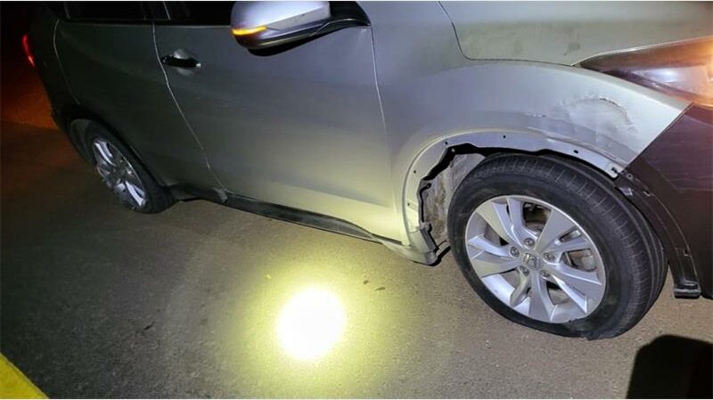 A car with its front end damaged by a light.