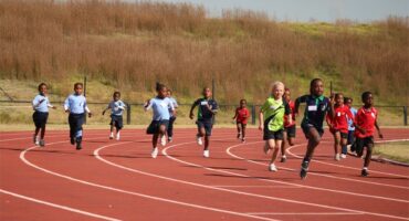 A group of kids running on a track.