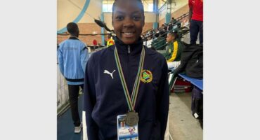 A woman with a medal standing in front of a crowd.