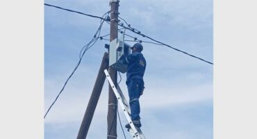 A man is working on a power pole.