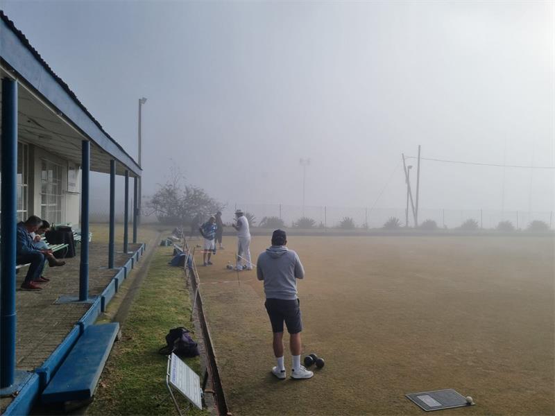 People playing on a field in the fog.