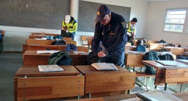 A man in a safety vest is working on a desk.