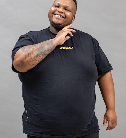 A man with a tattoo on his arm posing for a picture.