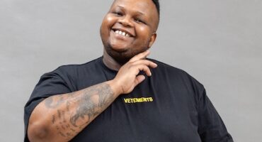 A man with a tattoo on his arm posing for a picture.