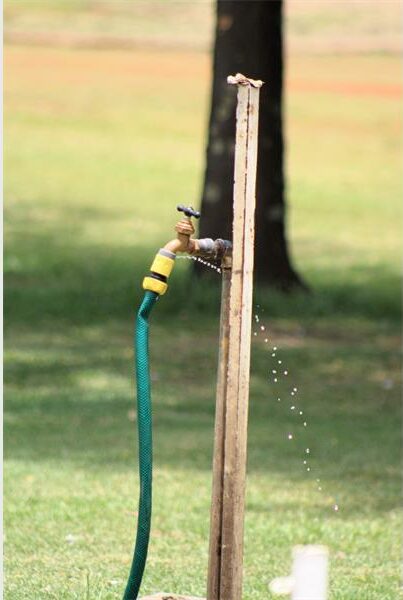 A hose is attached to a wooden pole.