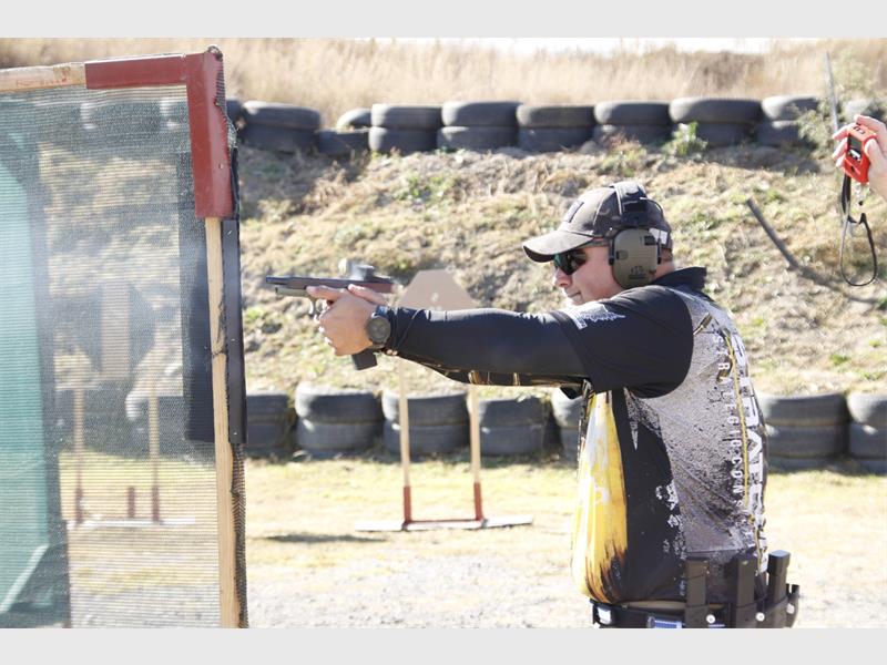A man is shooting a gun at a target.
