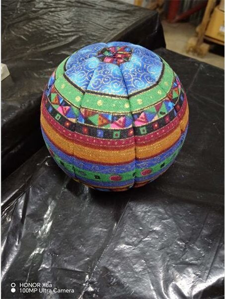 A colorful egg sitting on top of a black table.