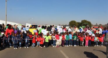 A group of children and adults standing in a line.