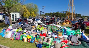 A large pile of items on the grass near a windmill.